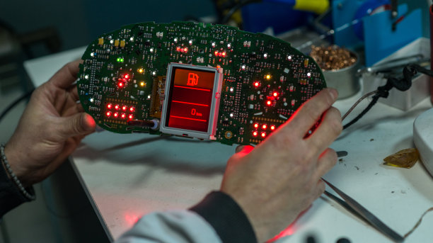 汽车机械师工作在仪表盘电子电路板，库存照片图片下载