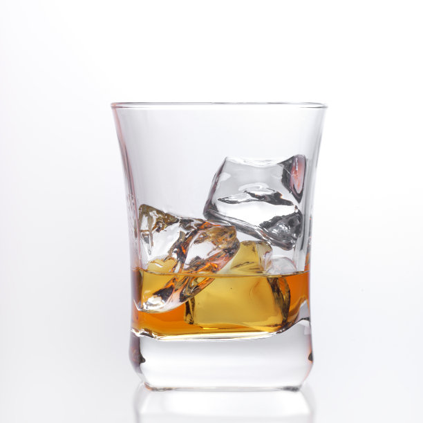 一杯琥珀色苏格兰威士忌加冰块，背景明亮图片下载