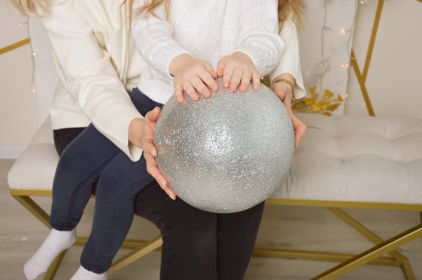 妈妈和女儿拿着一个闪亮的灰色气球。冬天的假期。图片下载