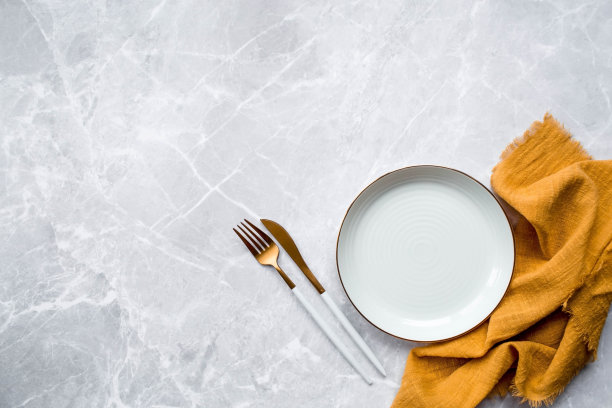 横幅。一个空陶瓷盘子，叉子，刀和毛巾在灰色的混凝土桌子的背景下。空间的文本。咖啡馆和餐厅的菜单概念。图片下载