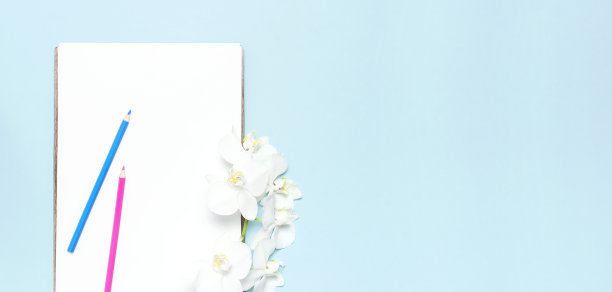 蝴蝶兰兰花花的分支，空白的白纸纸，蓝色背景的彩色铅笔顶视图平躺为您的设计规划概念模型。女性桌面热带花图片下载