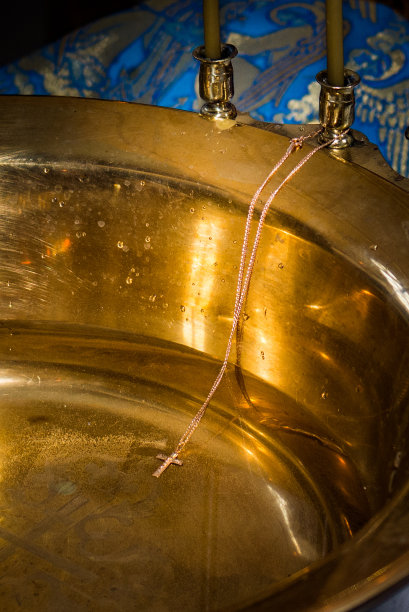 一个宗教十字架，用链子挂在教堂盛水的碗里的烛台上图片下载