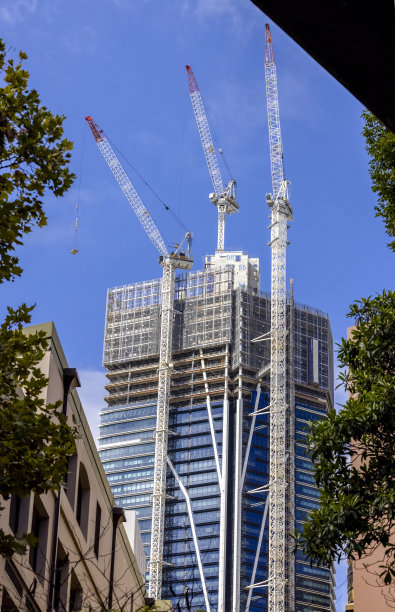 城市中带塔式起重机的摩天大楼建设，天空背景带复制空间图片下载