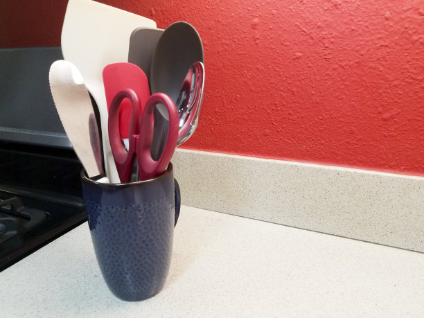 家用厨房里放在柜台上的炊具。容器是一个高大的陶瓷饮料杯，它是器皿的绝佳容器。图片下载