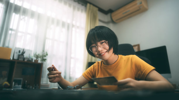 年轻的成年亚洲妇女在家里玩桌面游戏。图片下载