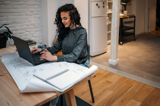 女建筑师在家工作。她希望蓝图。图片下载