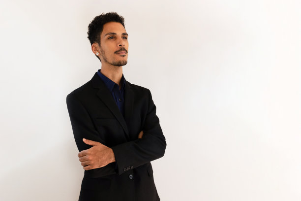 一个穿着社交t恤的黑人在工作室里被黄色的背景孤立起来。孤立的商人，充满戏剧性的光芒。图片下载