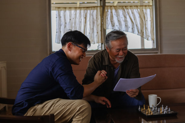 父亲正在教导他的儿子和建议如何管理开支和支付。图片下载