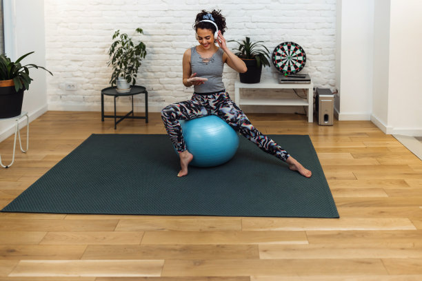 年轻漂亮的女运动员笑着开心。在健身房的瑜伽课上使用健身球进行锻炼图片下载