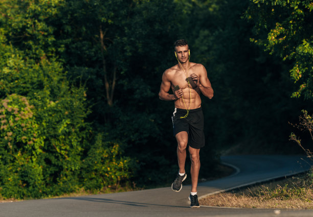 男性跑步者在夕阳升起，在美丽的自然山图片下载