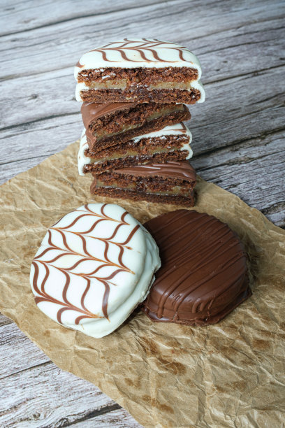 传统的巴西蜂蜜蛋糕配白巧克力糖霜。里面塞满了牛奶焦糖。在背景中，几张被切成两半并堆叠起来的垂直照片。图片下载