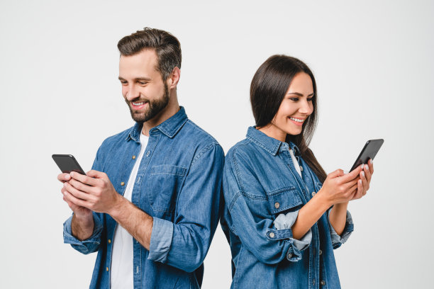手机成瘾。白种人年轻夫妇，配偶，男女朋友，在白色背景中使用手机上网，分享照片，电子学习，电子商务图片下载