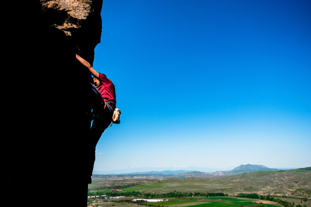 男人在爬一座非常陡峭的山-攀岩图片下载