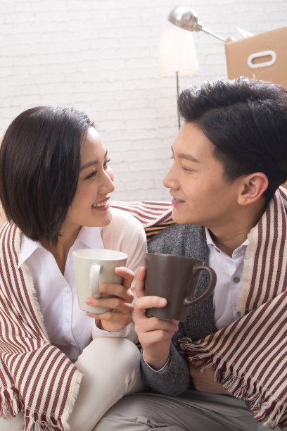 年轻夫妇坐在地板上喝水图片下载