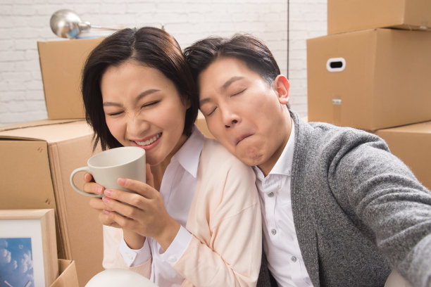 年轻夫妇坐在地板上喝水图片下载