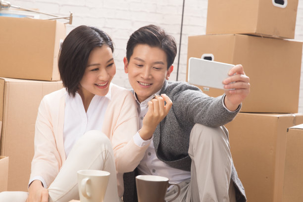 年轻夫妇用手机拍照图片下载