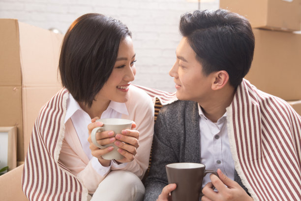 年轻夫妇坐在地板上喝水图片下载