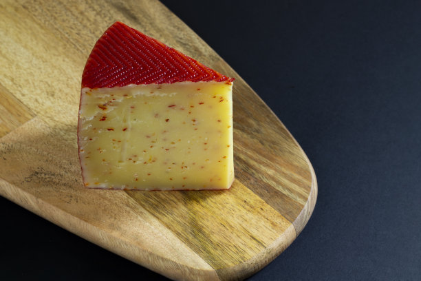 一块硬奶酪，配上红辣椒和帕尔马干酪，放在木板上图片下载
