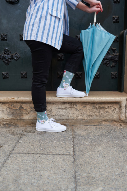 一个不认识的女人倚着她的蓝色雨伞站在门口图片下载