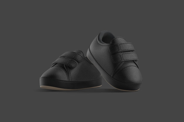 空白黑色婴儿鞋对在脚尖上的模型，黑色的背景图片下载