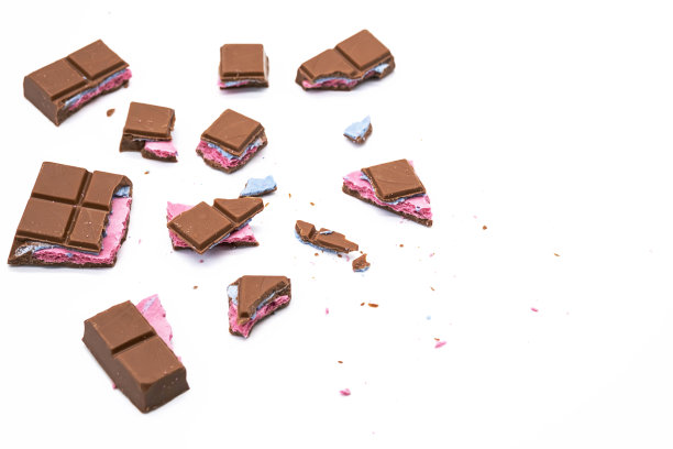 碎巧克力棒与粉红色蓝色填充在白色。各种大小的碎巧克力棒，合上。图片下载
