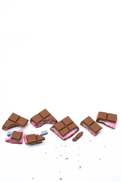 碎巧克力棒与粉红色蓝色填充在白色。各种大小的碎巧克力棒，合上。图片下载