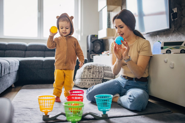 母亲和儿子在家里的客厅里玩玩具图片下载