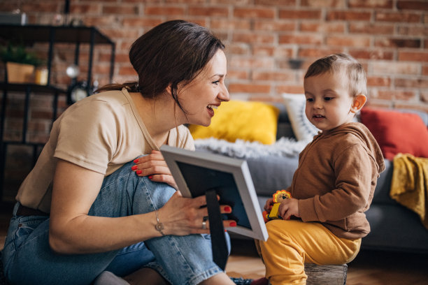 母亲和儿子在客厅玩玩具，看家庭照片图片下载