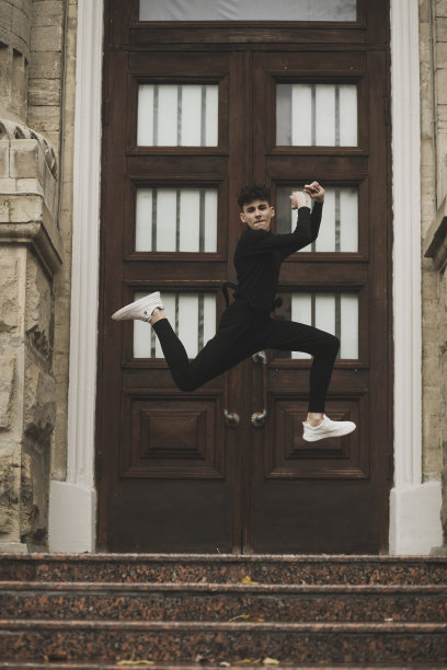 正面图片是一个穿着黑色衣服的少年在大楼上跳上跳下。图片下载