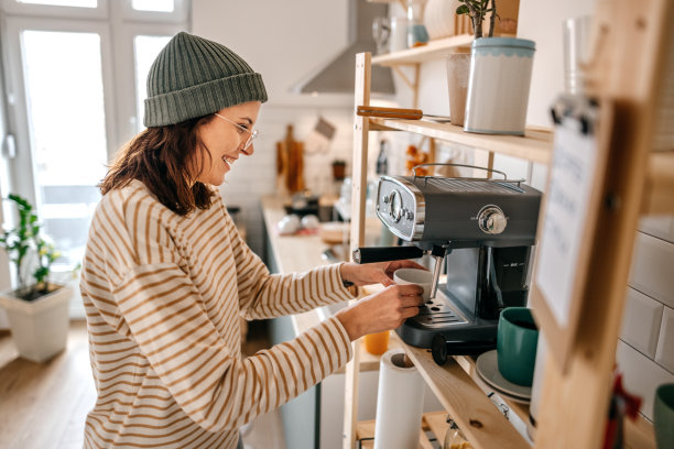 在厨房用机器煮咖啡的女人图片下载