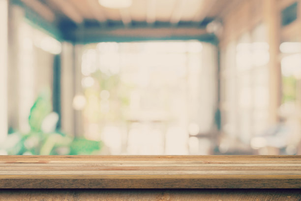 木制桌面与模糊的人在咖啡馆和咖啡馆背景显示蒙太奇，复制空间。图片下载