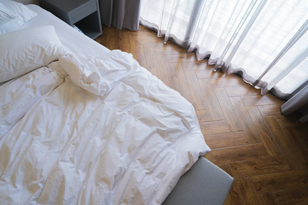 Topview白色皱毯床垫枕头在未经整理的床上与早晨的阳光通过大窗帘和纯粹的酒店房间等待女佣整理床后睡觉，家庭内部图片下载