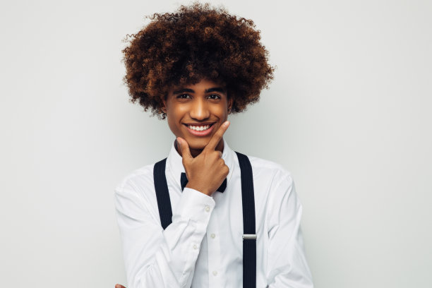 非洲裔美国人，留着非洲式发型，穿着白衬衫，站在孤立的白人背景上图片下载