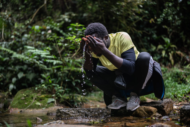 一个年轻人在森林里洗脸图片下载