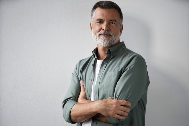 微笑的成熟男人站在白色背景的肖像图片下载