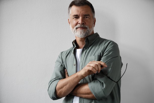 微笑的成熟男人站在白色背景的肖像图片下载