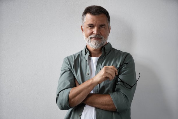 微笑的成熟男人站在白色背景的肖像图片下载