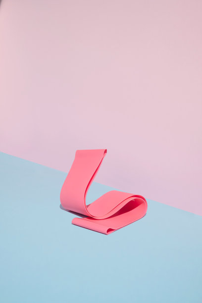 明亮的粉红色弹力臀带在粉红色和蓝色的背景。现代女性的健康或健美审美。图片下载