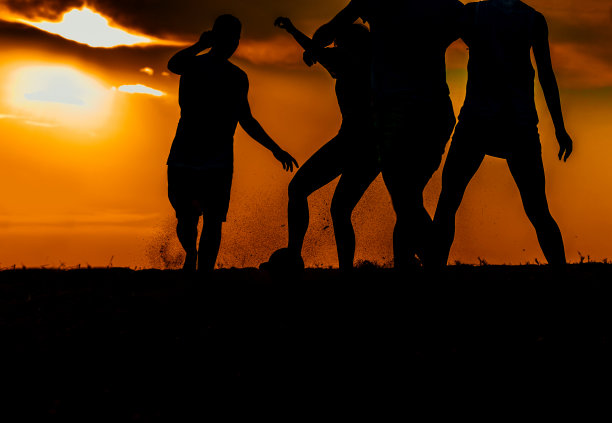 一群在沙滩上享受足球比赛的人图片下载