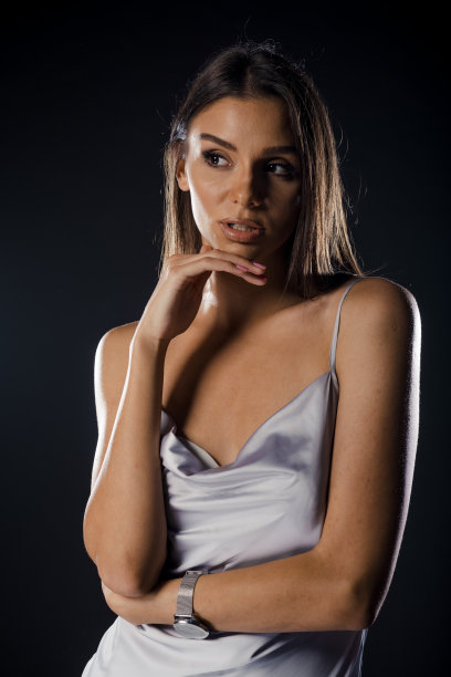 年轻漂亮的女人穿着黑色背景的白裙子图片下载