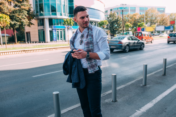 商人走在拥挤的城市中间的街道上，看起来很严肃图片下载