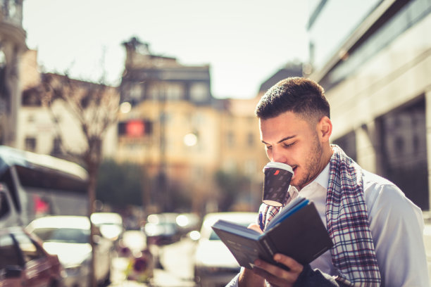 城市商人喝着咖啡，在笔记本上写着图片下载