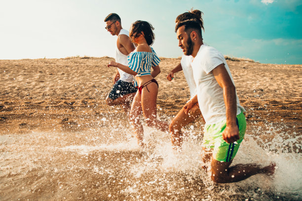 一群在海滩上冲浪的青少年图片下载