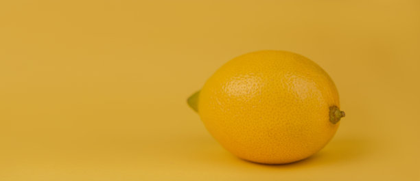 柠檬黄的背景。黄色柠檬特写在黄色的背景上。图片下载