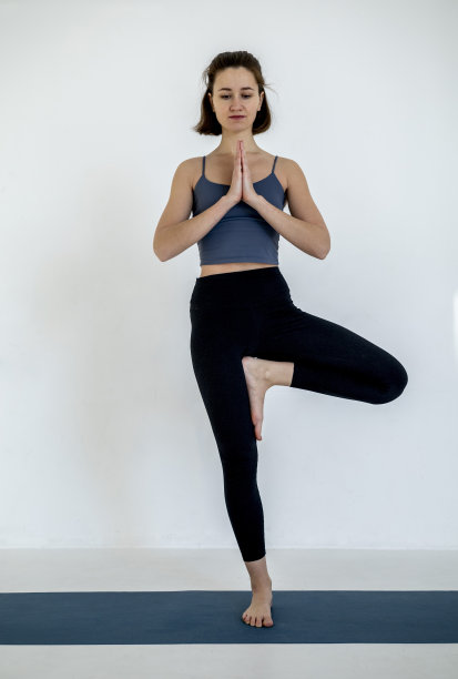 美丽的女孩练习体位在蓝色瑜伽垫。健康的生活方式。运动和健身。图片下载