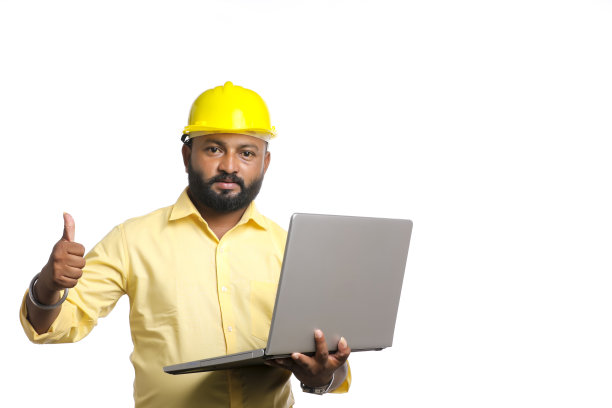 年轻的印度工程师穿着制服，在白色背景下使用笔记本电脑。图片下载