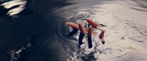 纤细的女性之手从黑暗的水中浮现。带光束的圆波。自然美容护理的隐喻。图片下载