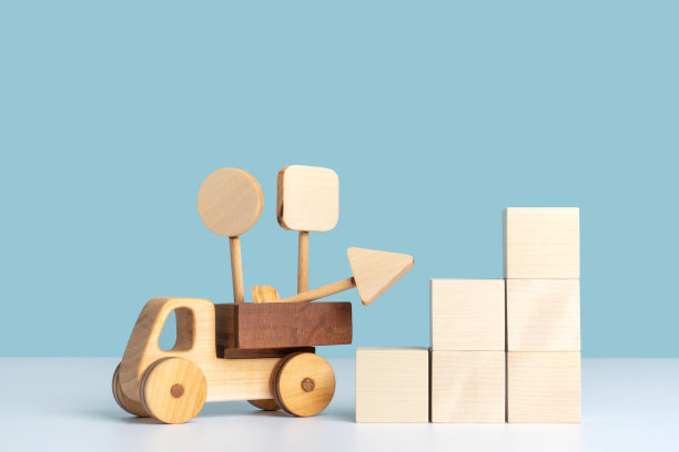 木制玩具车，卡车后面有玩具路标。商业交付，物流，道路维修的模型。复制空间在蓝色的背景图片下载