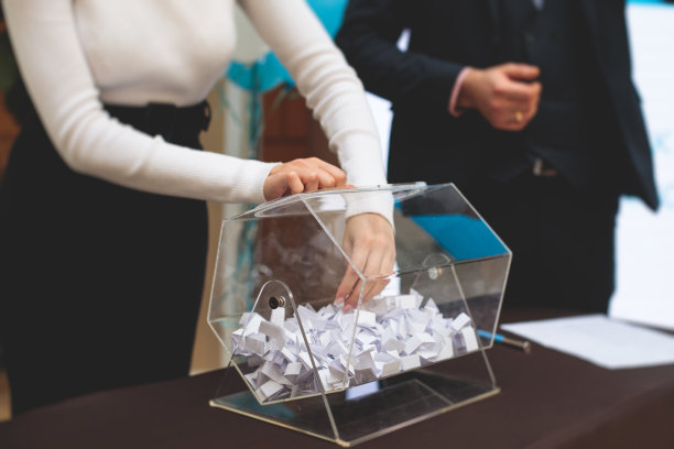 抽奖的过程，抽取彩票机的中奖号码，抽奖鼓与宾果球和中奖彩票的事件与主持人和手的彩票机图片下载