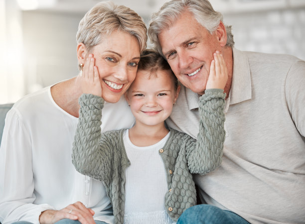 这是一对快乐的老夫妇和他们的孙女在家里的沙发上放松的照片图片下载